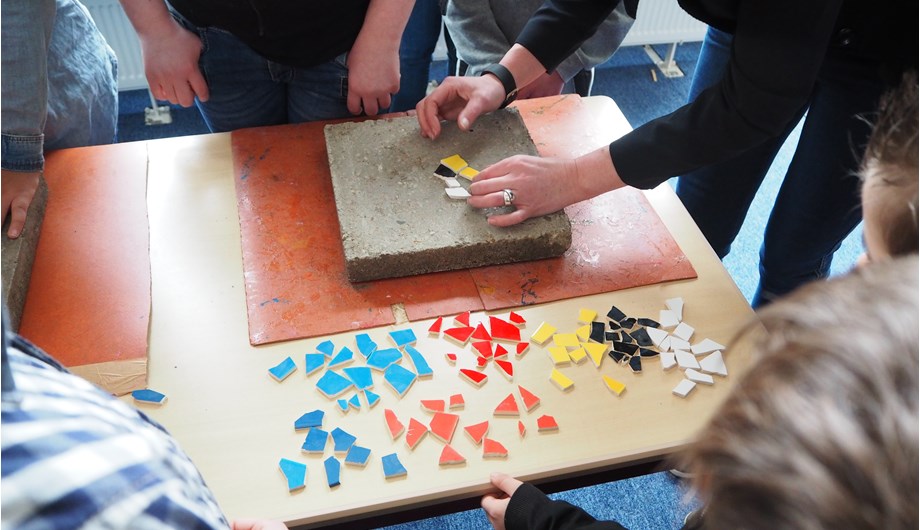 Hier maken de kinderen de tegels die voor de school zijn neergelegd.