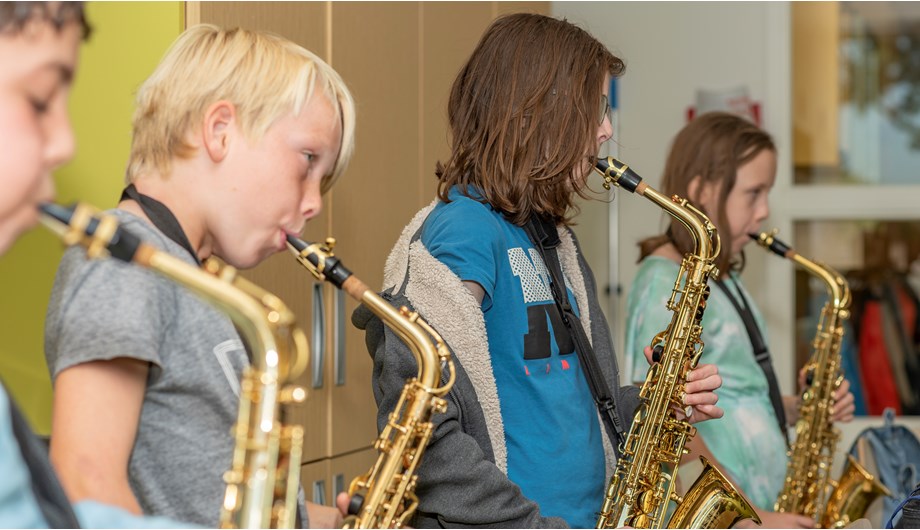 In samenwerking met de muziekvereniging Crescendo lerende kinderen spelen op blaas- en slaginstrumenten.
