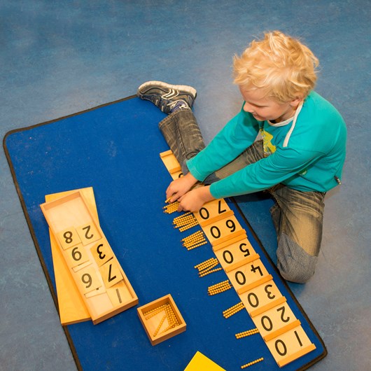 Ook rekenen leren de kinderen door te doen. Het kind ziet het getal in cijfers en legt daarnaast met het gouden materiaal/ kralen naast. 