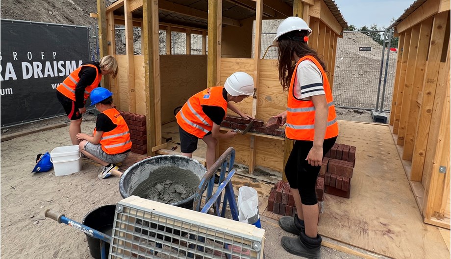 Kinderen uit de bovenbouw mochten een dagdeel "bouwen" ervaren op de bouwplaats van het nieuwe zwembad.