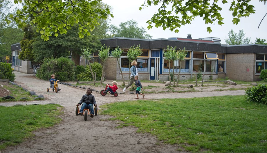 Het grote en groene schoolplein van De Regenboog biedt de kinderen een uitnodigende omgeving voor samen spelen