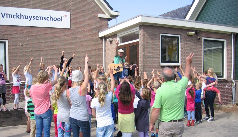 Het schoollied zingen met de hele school. Vanwege het mooie weer lekker buiten. Op de website is het lied te beluisteren.