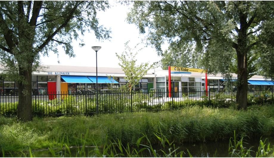 De school ligt ten zuiden van het wijkpark Woudhoek.