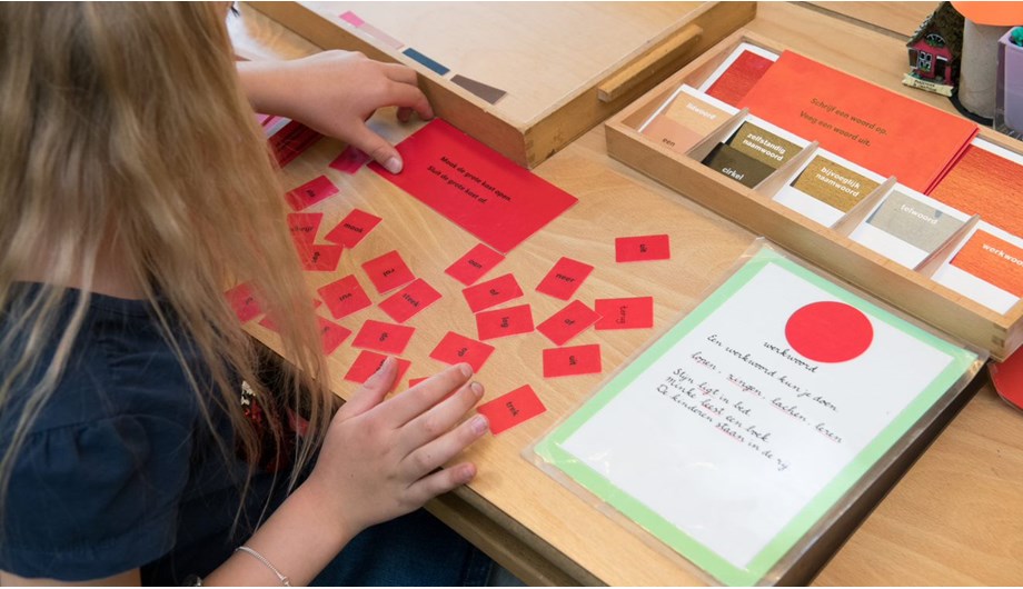Kinderen leren de woordsoorten met de gekleurde taaldozen.